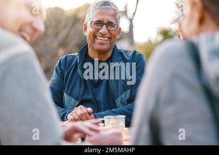 Heureux, échecs ou couple d'amis dans la nature jouant un jeu de société, le collage ou parler d'une histoire drôle. Garez, soutenez ou des personnes âgées en bonne santé Banque D'Images