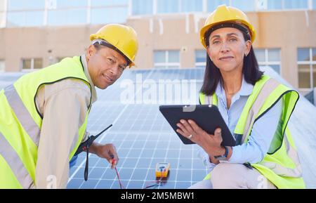 Tablette, énergie solaire ou équipe d'ingénieurs travaillant des panneaux solaires ou de la technologie sur le toit pour l'énergie renouvelable. Travail d'équipe, portrait ou construction Banque D'Images