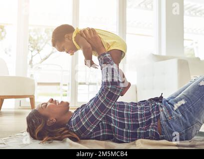 Je n'en reste pas pour vous soutenir. une jeune mère et sa petite fille à la maison. Banque D'Images