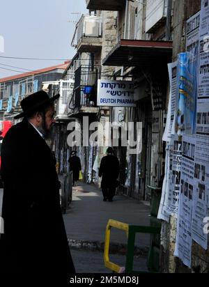 Un homme de Haredi lisant le panneau d'affichage gémissant dans le quartier de MEA He'arim à Jérusalem, en Israël. Banque D'Images