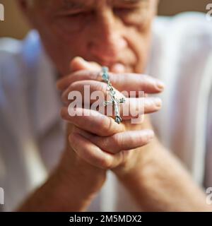 Garder la foi vivante. Plan court un homme âgé tenant un rosaire dans la prière. Banque D'Images