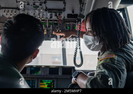 Le Sergent d’état-major Toiannah Campbell, maître de répartition de l’escadron de transport aérien 36th, explique comment les États-Unis La Force aérienne effectue des inspections avant vol à l'intérieur d'un C-130J Super Hercules au sergent d'état-major Naoki Souma, membre de la Force aérienne japonaise d'autodéfense, au cours d'une immersion bilatérale de NCO sur la base aérienne de Yokota, au Japon, en 25 mars 2022. Le Programme d'échange bilatéral vise à renforcer le partenariat entre les États-Unis et le Japon et à accroître l'interopérabilité entre les États-Unis Air Force et JASDF grâce à une expérience pratique. Banque D'Images