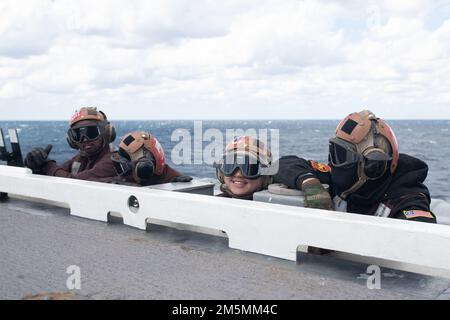 Les marins affectés au « Golden Warriors » du Strike Fighter Squadron (VFA) 87 observent les opérations de vol depuis le bord du pont de l’USS Gerald R. Ford (CVN 78), 26 mars 2022. Ford est en cours dans l’océan Atlantique en menant la certification de plate-forme de vol et la qualification de transporteur aérien dans le cadre de la phase de base sur mesure du navire avant le déploiement opérationnel. Banque D'Images