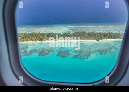 Fenêtre d'avion avec belle vue sur l'île des Maldives. Vacances d'été de luxe voyage tourisme fond, vue de la fenêtre d'avion. Îles atolls Banque D'Images
