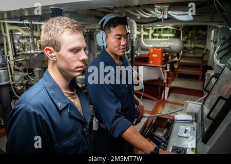 MER DES PHILIPPINES (27 mars 2022) Ensign Xavier Brenza, à gauche, de Boulder (Colorado), et Ensign Brian Li, de Carmel (Indiana), homme à bord du destroyer de missile guidé de classe Arleigh Burke USS Dewey (DDG 105) tout en participant à l'entraînement tactique avancé de guerre de surface (SWATT). SWATT offre à la flotte l'occasion de réaliser l'exercice tactique requis pour accroître la létalité et la compétence tactique. Banque D'Images