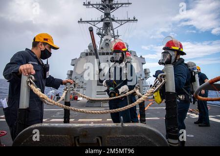 LES marins DE LA MER DES PHILIPPINES (27 mars 2022) affectés au destroyer de missile guidé de classe Arleigh Burke USS Dewey (DDG 105) participent à un exercice d'équipe de contrôle des dégâts lors de l'entraînement tactique avancé de la guerre de surface (SWATT). SWATT offre à la flotte l'occasion de réaliser l'exercice tactique requis pour accroître la létalité et la compétence tactique. Banque D'Images