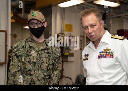 SYDNEY (28 mars 2022) – les champs Dakota de classe 2nd du compagnon d'électricien, affectés à l'agent sous-marin de classe Emory S. Land USS Frank Cable (AS 40), explique son travail dans l'atelier de rembobinage automobile au vice-ADM de la Marine royale australienne Michael Noonan, chef de la Marine australienne, lors d'une visite du navire, 28 mars. Frank Cable est actuellement en patrouille pour la maintenance et la logistique des expéditions à l'appui de la sécurité nationale dans la zone d'opérations de la flotte américaine 7th. Banque D'Images