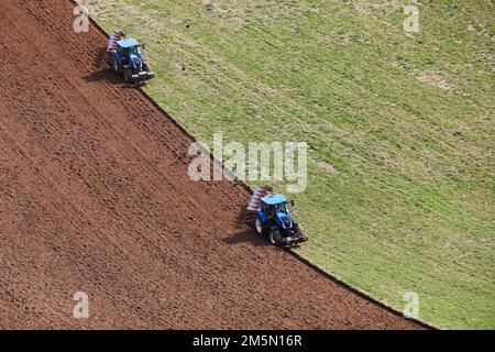 Deux tracteurs photographiés cultivent Goodwood à Chichester, West Sussex, Royaume-Uni. Banque D'Images