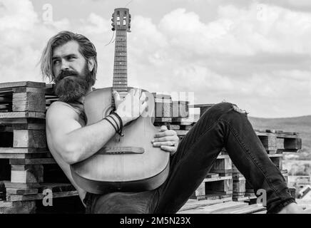 faites une pause. musicien de musique. instrument de musique à cordes. guitariste mâle mature charismatique. un gars avec la barbe et la moustache joue de la guitare Banque D'Images