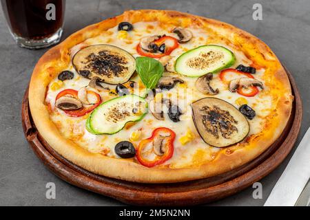 Pizza végétarienne avec aubergines, courgettes et champignons sur une table en pierre sombre Banque D'Images
