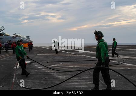 Les marins DE LA MER DE CHINE DU SUD (29 mars 2022) remplacent un câble d'arrêt sur le pont de vol du porte-avions de la classe Nimitz USS Abraham Lincoln (CVN 72). Abraham Lincoln Strike Group est en cours de déploiement prévu dans la zone d'exploitation de la flotte américaine 7th afin d'améliorer l'interopérabilité par le biais d'alliances et de partenariats tout en servant de force de réaction prête à l'emploi pour soutenir une région libre et ouverte d'Indo-Pacifique. Banque D'Images