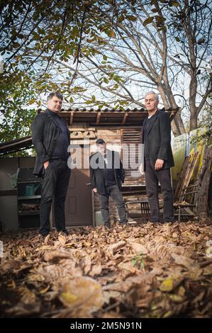 Portrait de l'artiste urbain et beau à la mode gars pose dans noir élégant costumes d'extérieur Banque D'Images