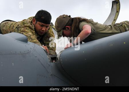 Personnel Sgt Bobby Khamphoumy, 374th Groupe de maintenance C-130J Chef de l'équipage de conduite Super Hercules, à gauche, et ancien Airman Rylee Johnson, 374th MXGC-130J compagnon de propulsion aérospatiale, travaux de réparation d'un moteur C-130J à l'aérodrome U-Tapao Royal Thai Navy, Thaïlande, 29 mars 2022. Il est impératif d'inclure des aviateurs d'entretien sur des possibilités de formation comme celles-ci pour assurer la sécurité et le succès de la mission. Banque D'Images