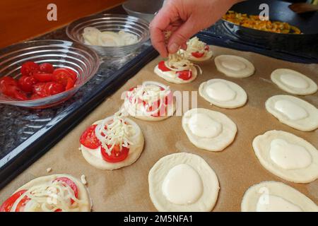 Cuisine souabe, préparation Mini-Dinnete, également Dennete, Dinnede, Dennetle, pâte de levure copieuse, salée et crue saupoudrée de fromage râpé Banque D'Images