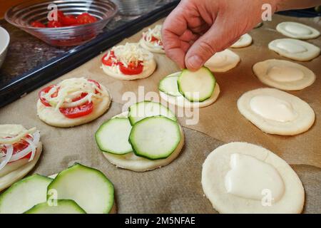 Cuisine souabe, préparation de mini dinnete, également dennete, dinnede, dennete, copieuse, salées, garniture de pâte de levure crue avec tranches de courgette Banque D'Images