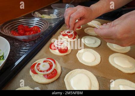 Cuisine souabe, préparation de Mini-Dinnete, également Dennete, Dinnede, Dennetle, pâte de levure copieuse, salée et crue, recouverte de rondelles d'oignon Banque D'Images