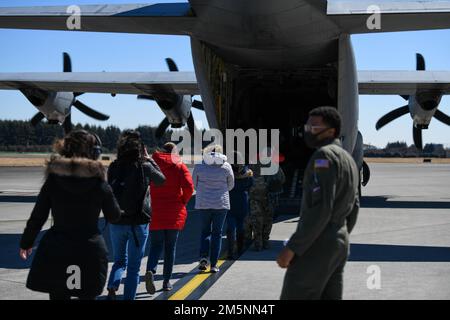 Les conjoints de Yokota entrent dans la rampe de sortie arrière d'un C-130J Super Hercules affecté au Escadron de transport aérien 36th dans le cadre d'un vol d'orientation pour les conjoints à la base aérienne de Yokota, au Japon, le 25 février 2022. Les conjoints ont eu l'occasion de voler sur les C-130, UH-1N Huey et C-12 Huron dans le cadre de la journée d'orientation. Banque D'Images