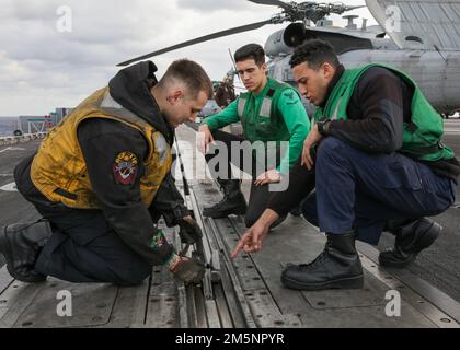 MER DES PHILIPPINES (26 février 2022) des marins à bord du porte-avions de la classe Nimitz USS Abraham Lincoln (CVN 72) inspectent un ensemble de lancement de train de nez en préparation aux opérations de vol. Abraham Lincoln Strike Group est en cours de déploiement prévu dans la zone d'exploitation de la flotte américaine 7th afin d'améliorer l'interopérabilité par le biais d'alliances et de partenariats tout en servant de force de réaction prête à l'emploi pour soutenir une région libre et ouverte d'Indo-Pacifique. Banque D'Images