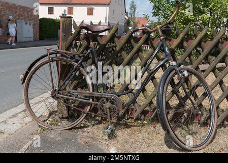 Vélo des vieilles dames autour de 1930 penchée contre une clôture de jardin, Bavière, Allemagne Banque D'Images