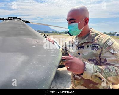 Le SPC. Raymond Sarmiento, aviateur de D Co “Cannibales”, 2nd Bataillon, 25th Aviation Regiment, 25th combat Aviation Brigade, 25th Infantry Division, effectue la maintenance de l'aviation le 26 février 2022 dans le cadre de l'exercice Cobra Gold 2022 dans la province de Lophuri du Royaume de Thaïlande. Cobra Gold 2022 est la version 41st de l'exercice international de formation qui soutient la préparation et met l'accent sur la coordination de l'action civique, de l'aide humanitaire et des secours en cas de catastrophe. Du 22 février au 4 mars 2022, cet événement annuel se déroule dans différents endroits du Royaume de Thaïlande à Banque D'Images