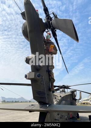 Benjamin Duben, aviateur du D Co “Cannibales”, 2nd Bataillon, 25th Aviation Regiment, 25th combat Aviation Brigade, 25th Infantry Division, effectue la maintenance aérienne le 26 février 2022 dans le cadre de l'exercice Cobra Gold 2022 dans la province de Lophuri du Royaume de Thaïlande. Cobra Gold 2022 est la version 41st de l'exercice international de formation qui soutient la préparation et met l'accent sur la coordination de l'action civique, de l'aide humanitaire et des secours en cas de catastrophe. Du 22 février au 4 mars 2022, cet événement annuel se déroule dans divers endroits de l'Inde du Royaume de Thaïlande Banque D'Images