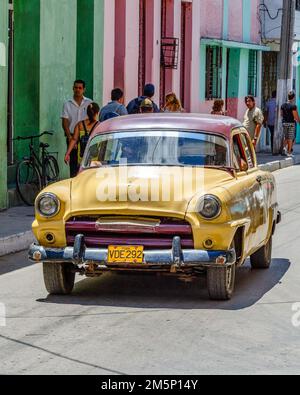 Une vieille voiture américaine se trouve à Colon St. Cuba les gens marchent dans le trottoir. Banque D'Images