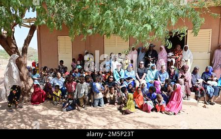 Membres de la base aérienne 201 Association des femmes, Association des femmes d'Aladab les membres et les enfants prennent une photo de groupe dans le village d'Aladab, Agadez, Niger, le 27 février 2022. Au cours de la visite, l’Association des femmes de 201 s’est engagée auprès de la communauté locale, a établi des relations et a acquis des connaissances sur le leadership dans une perspective différente selon le sexe. Banque D'Images