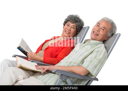 Heureux couple âgé assis sur une chaise de plage Banque D'Images