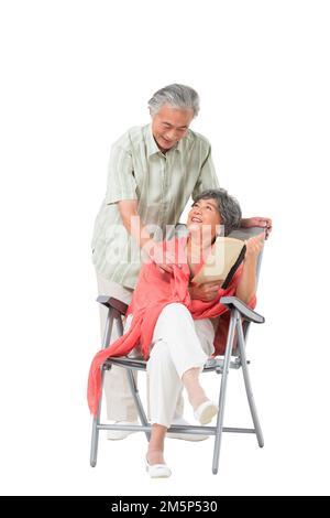 Heureux couple âgé assis sur une chaise de plage Banque D'Images