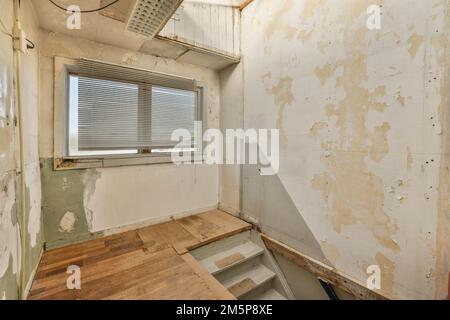 une chambre inachevée avec parquet et peeling sur les murs de cette vieille maison qui a besoin d'être réaménagé Banque D'Images