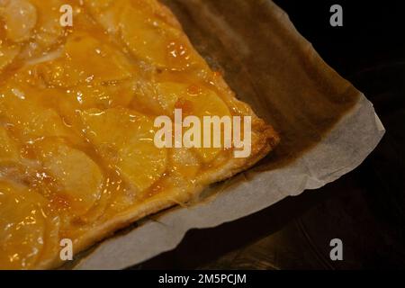 Tarte aux pommes maison, douce et lumineuse, fraîche du four sur son papier de cuisson Banque D'Images