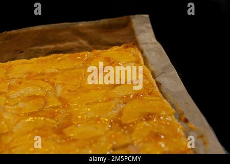 Tarte aux pommes maison, douce et lumineuse, fraîche du four sur son papier de cuisson Banque D'Images