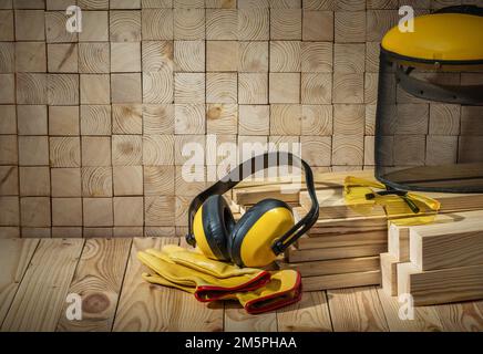 menuisier outils casque gants lunettes et masque de scie sur fond en bois Banque D'Images