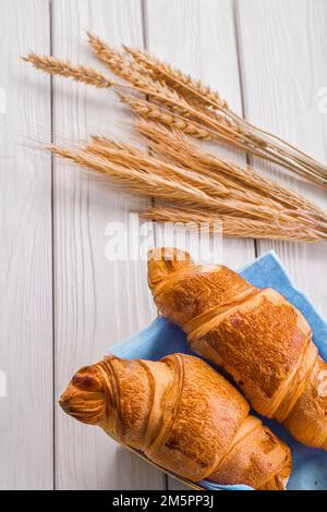 croissants et épis de blé sur bois blanc Banque D'Images