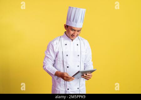 chef masculin portant une veste de chef à l'aide d'un coussin Banque D'Images