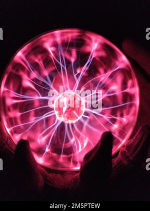 Un gros plan d'un globe de plasma lumineux dans l'obscurité. Banque D'Images