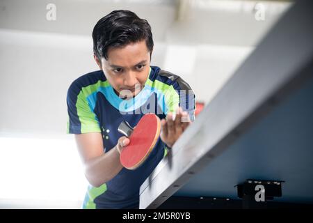 Gros plan de l'athlète masculin se concentrant pendant le service Banque D'Images