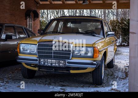 Château de Topacz, Pologne - 20 décembre 2022 : Mercedes Benz w123 200D jaune classique, vue de face. Banque D'Images