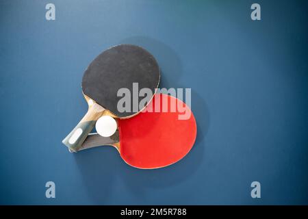 deux palettes avec une balle sur une table de ping-pong Banque D'Images