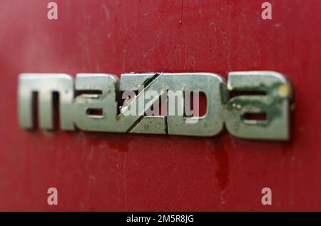 Bobruisk, Bélarus, 27 juillet 2022 : gros plan d'une Mazda rouillée sur une voiture rouge 90s. Banque D'Images