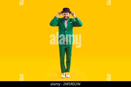 Portrait d'un homme souriant heureux portant un costume vert et un chapeau noir le jour de la St Patrick Banque D'Images