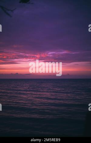 Une image verticale d'une mer avec un beau ciel rose et violet au-dessus Banque D'Images