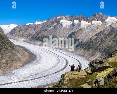 Bettmeralp, Suisse - 16 juillet 2022: Un jeune couple admire le paysage glaciaire du glacier d'Aletsch et de la vallée de glace en Suisse, appelée Aletsch Banque D'Images