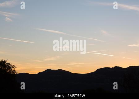 ciel parsemé de pistes d'avion au crépuscule en automne Banque D'Images