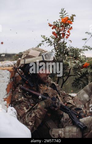 Un défenseur ukrainien lors d'un tir d'artillerie ennemi sur la ligne de front. Guerre entre l'Ukraine et la Russie. Banque D'Images