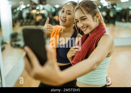deux femmes asiatiques heureuses prenant des selfies ensemble à l'aide d'un téléphone portable Banque D'Images