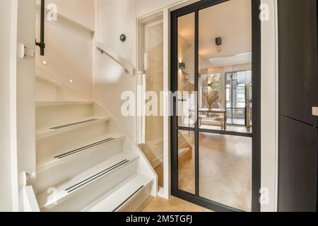 une maison moderne avec une porte ouverte menant au salon et à la salle à manger dans la photo est prise de l'intérieur Banque D'Images