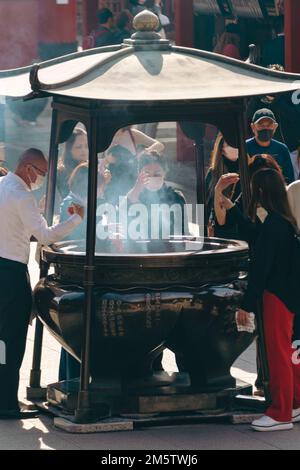 Touristes au temple Sensoji faisant des rituels Banque D'Images