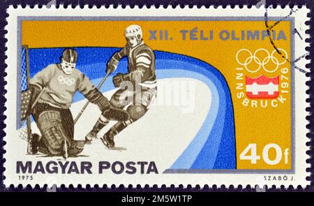 Timbre-poste annulé imprimé par la Hongrie, qui montre Hockey, faisant la promotion des Jeux Olympiques d'hiver à Innsbruck, vers 1975. Banque D'Images