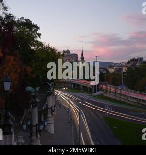 Ville au coucher du soleil à partir d'une colline voitures passant de longues bandes lumineuses Banque D'Images